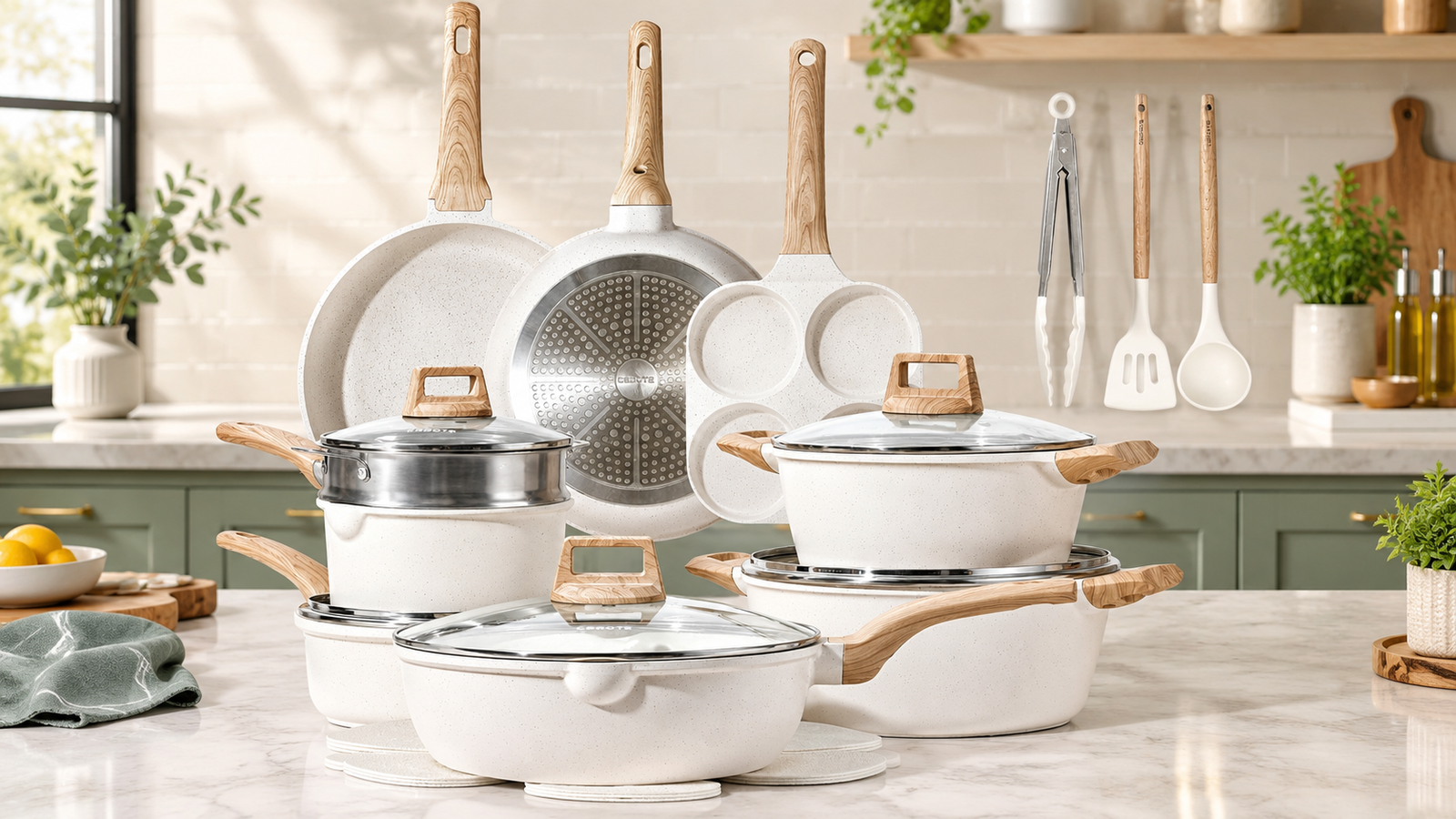 CAROTE cookware set in cream white with frying pans, pots, lids and utensils on a kitchen counter